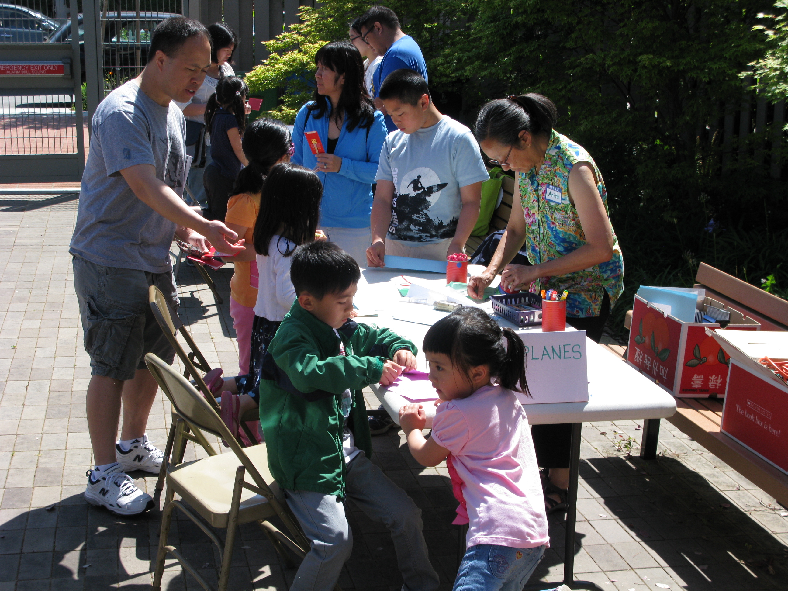 Children, parents and staff at an activity table outside
