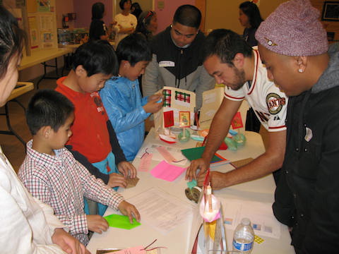 Students showing children how to do the activity