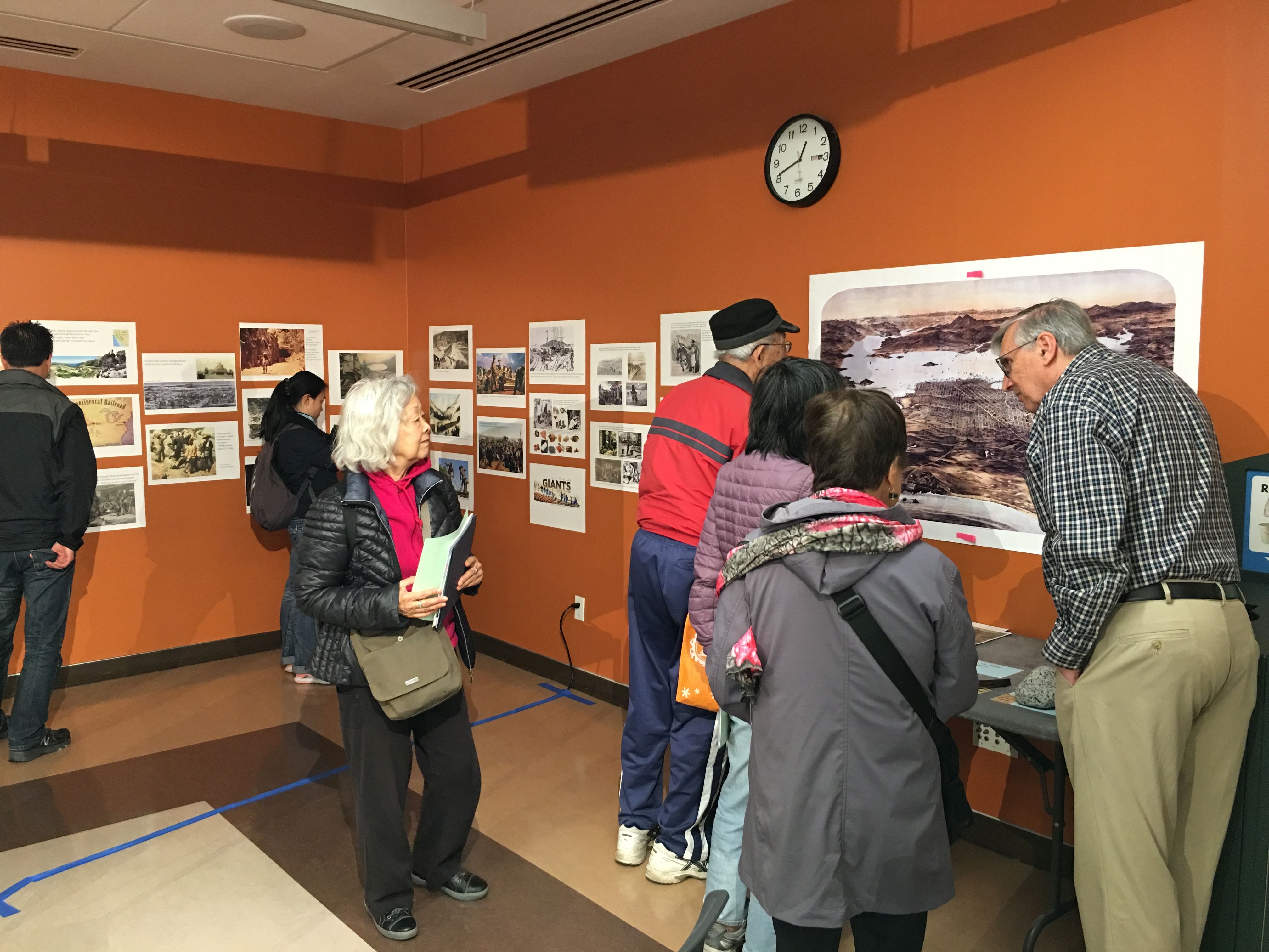 Adults looking at the wall exhibit