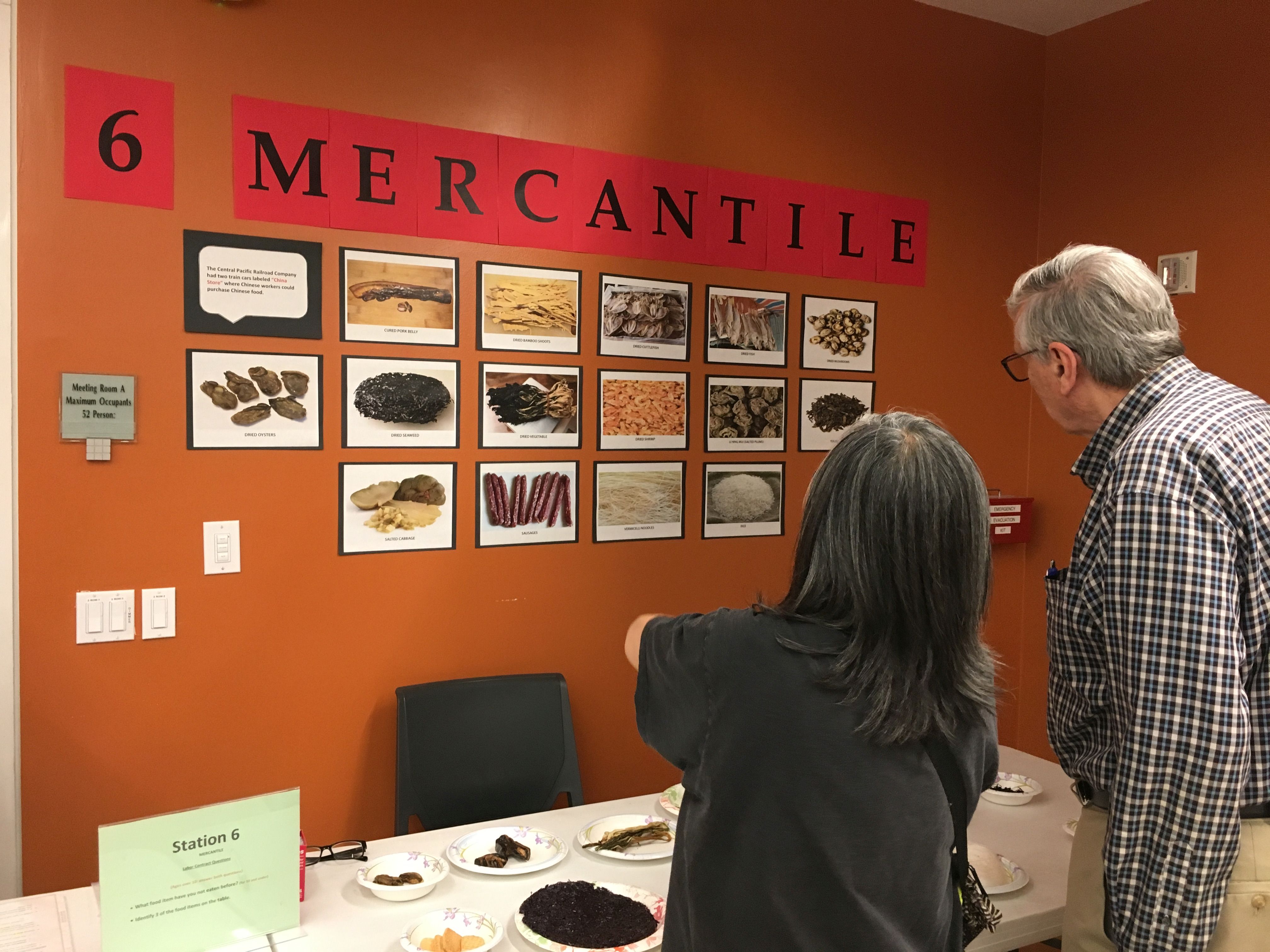 Two adults look at the Mercantile wall